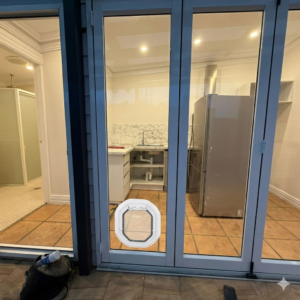 Dogwalk Slim Line dog door in white fitted low into a framed glass door