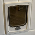 White Catwalk wood-fitting cat door seen from inside a timber door