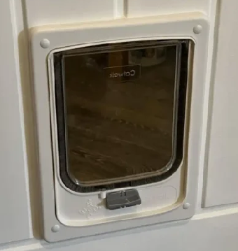 White Catwalk wood-fitting cat door seen from inside a timber door