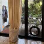 Black Dogwalk dog door fitted low in the glass of a black-framed aluminium door, opening onto a deck and garden